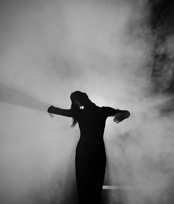 Woman performing a fluid cardio movement in a bright, minimalist space.